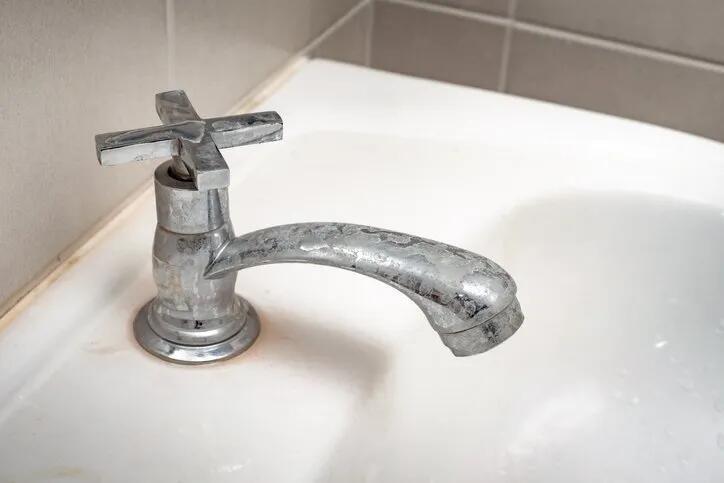 Bathtub faucet covered in hard water stains